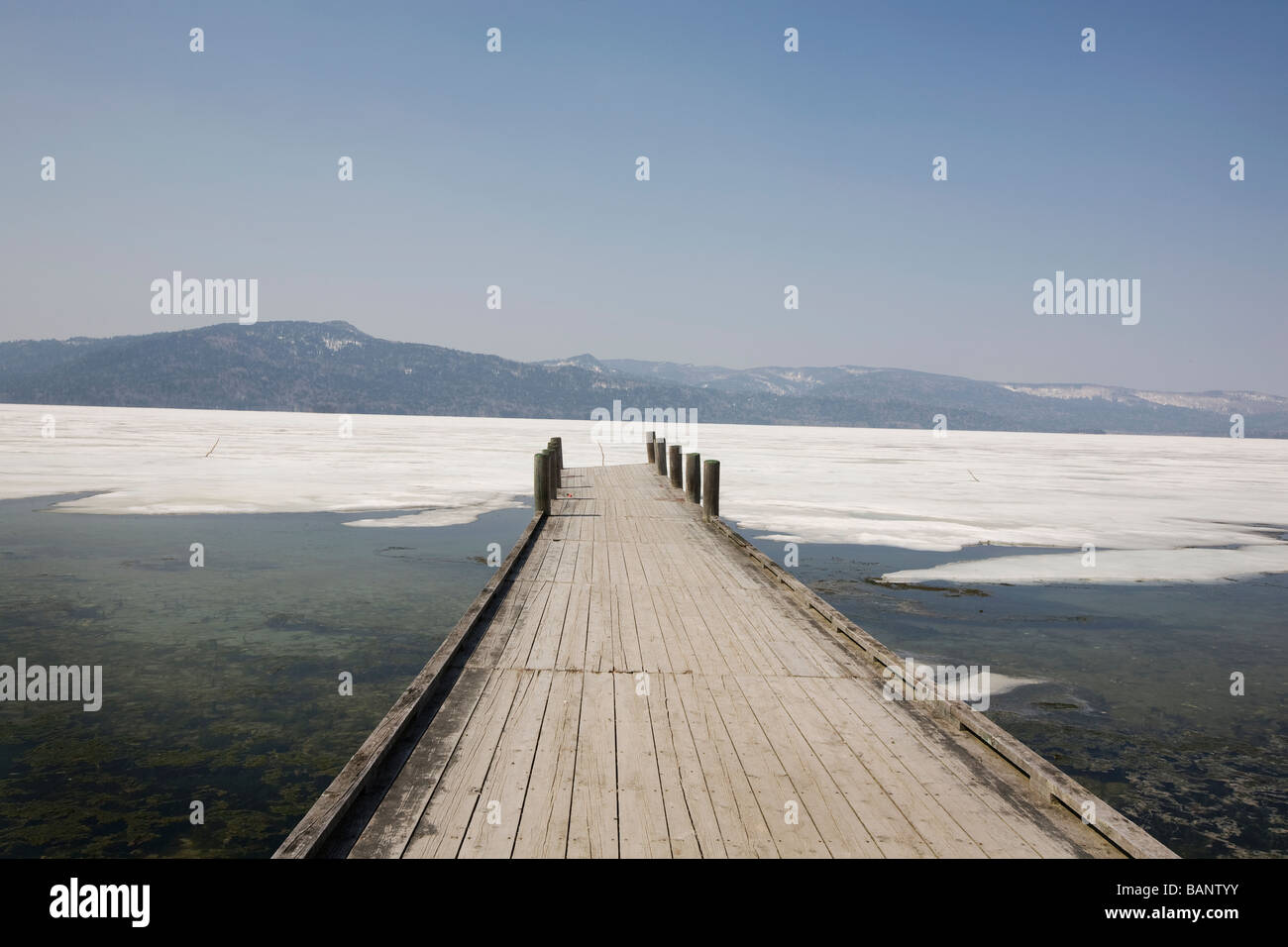 A pier runs out into the frozen waters of Lake Akan Hokkaido Japan on Monday 13th April 2009 Stock Photo