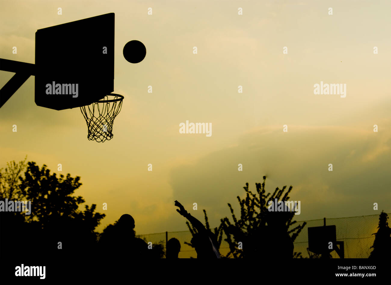 A basketball on course for the net. Dusk in Finsbury Park North London. Stock Photo