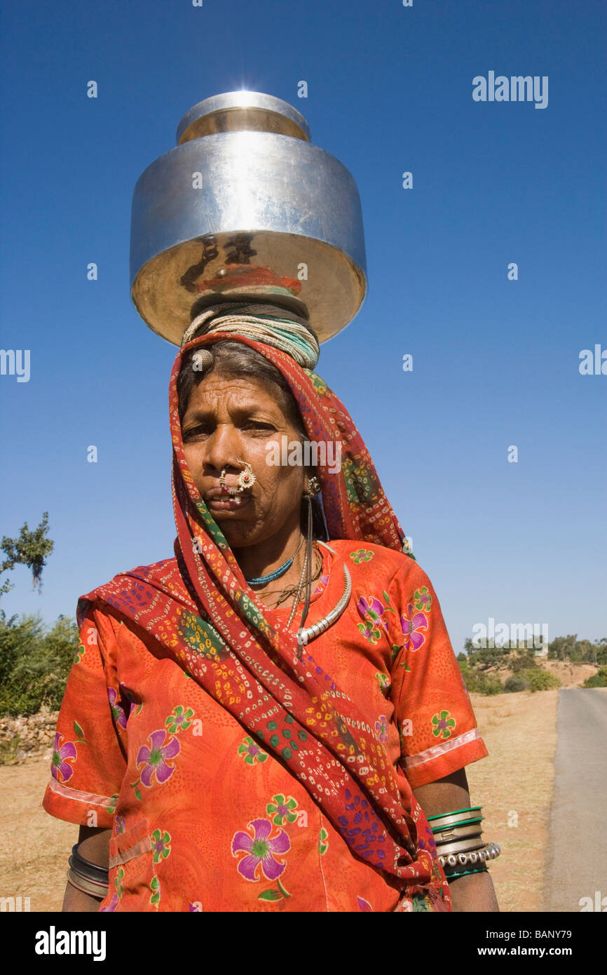Woman carrying brass pot on her head, Udaipur, Rajasthan, India Stock