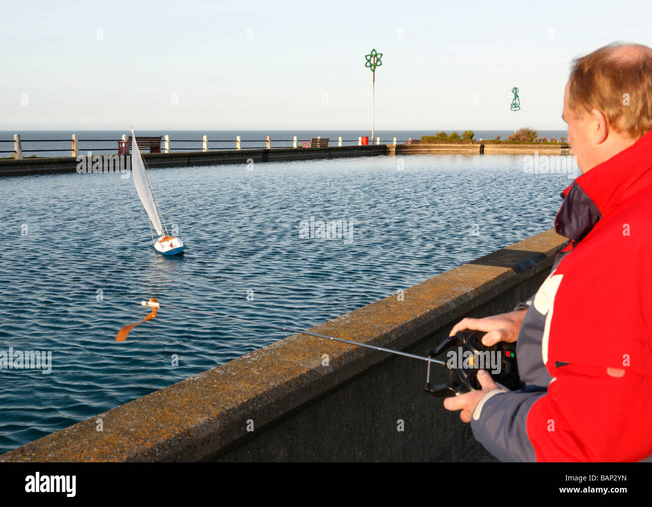 A man operating a remote controlled yacht Stock Photo