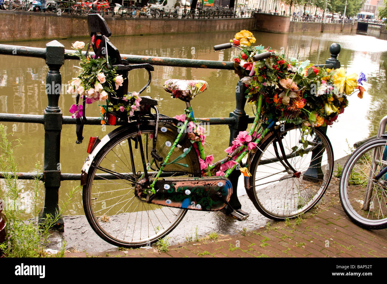 bicycle festooned or garlanded with articficial flowers on a canal bank
