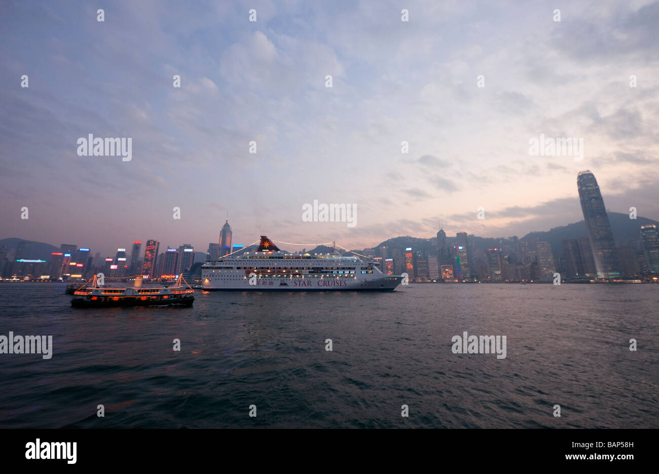 Skyline of Hong Kong at Dusk - Cruise Ship and Star Ferry in front of Hong Kong Island, China, Asia Stock Photo