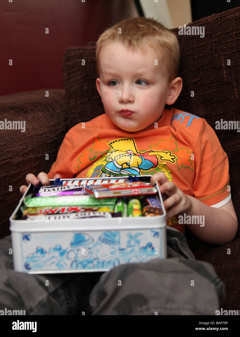 Chubby  four year old boy eating chocolate Stock Photo