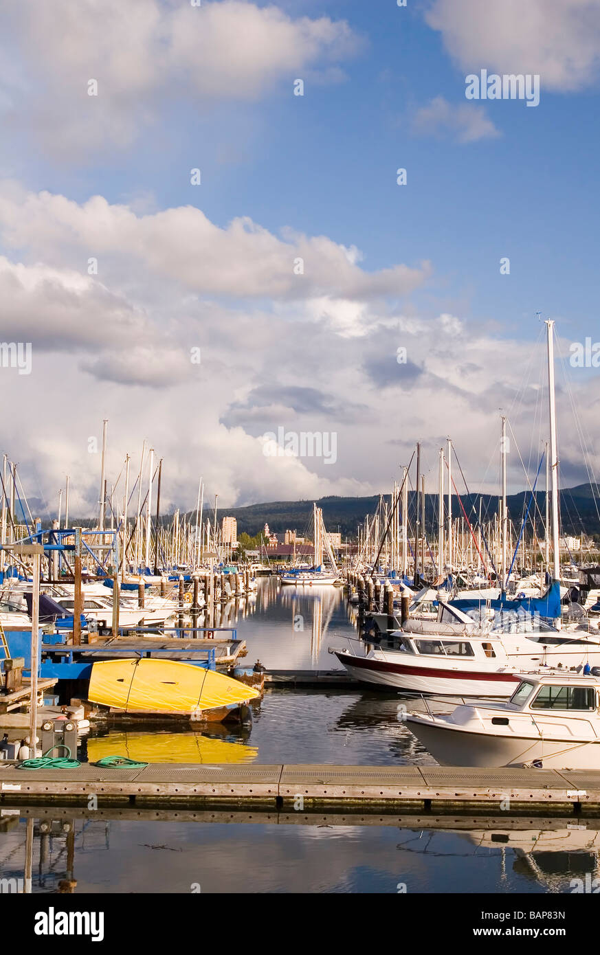 A small yellow boat between slips in a yacht marina Stock Photo - Alamy