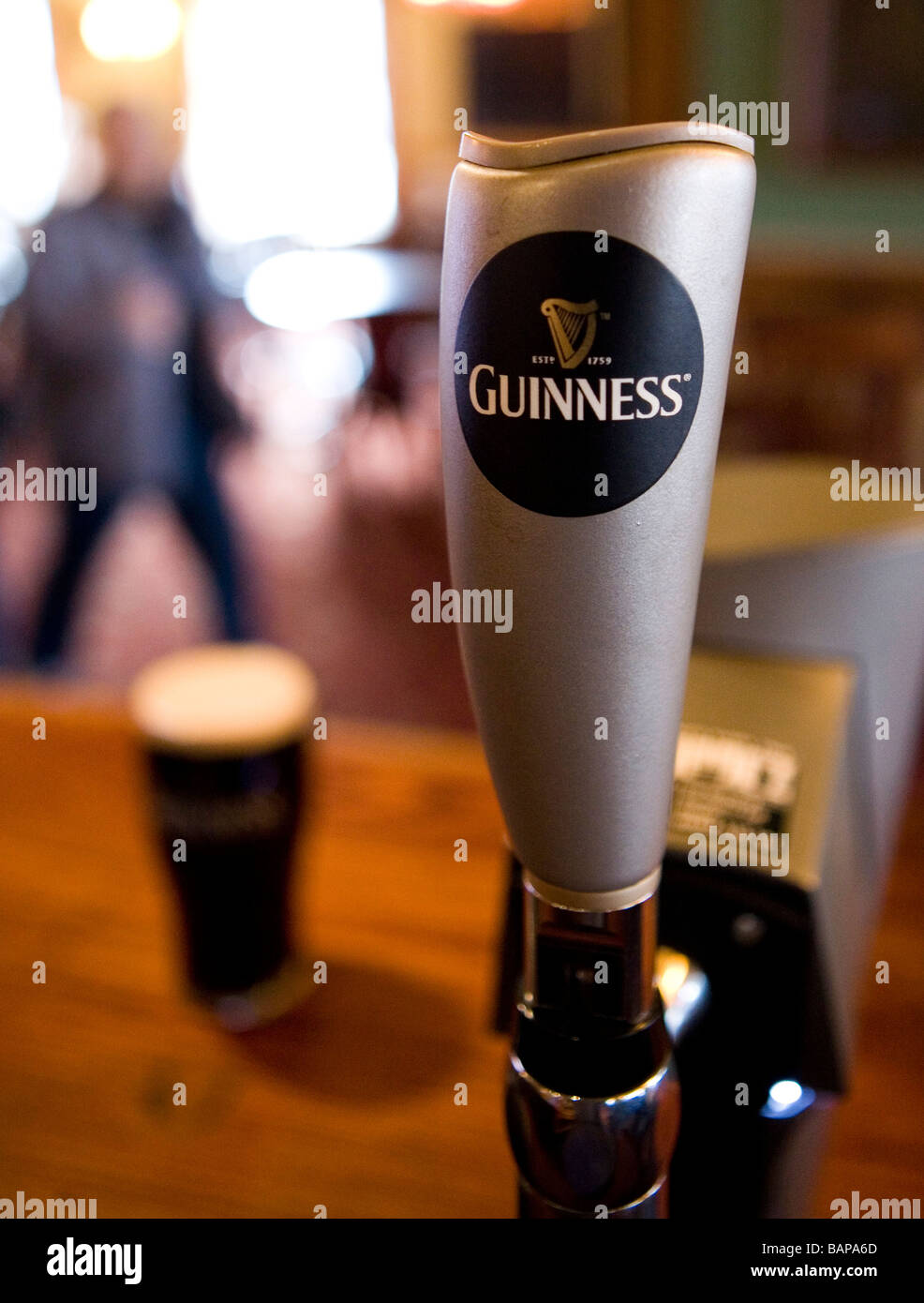 The Guinness Harp is seen on the pump as a pint sits on the bar Stock