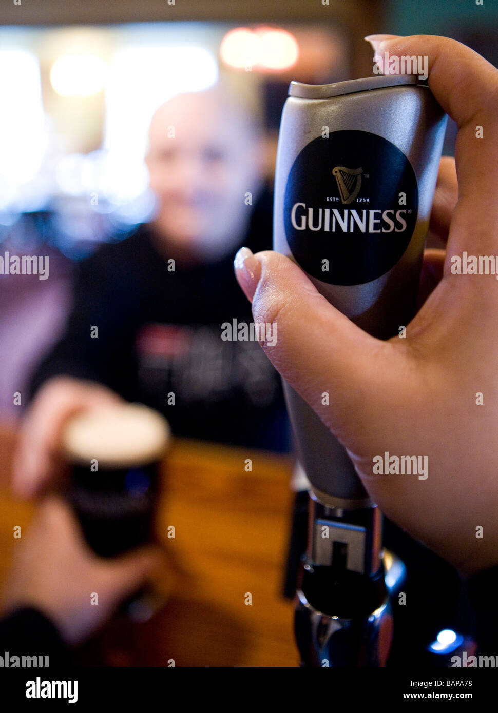 The Guinness Harp is seen on the pump as a pint is served to a customer ...