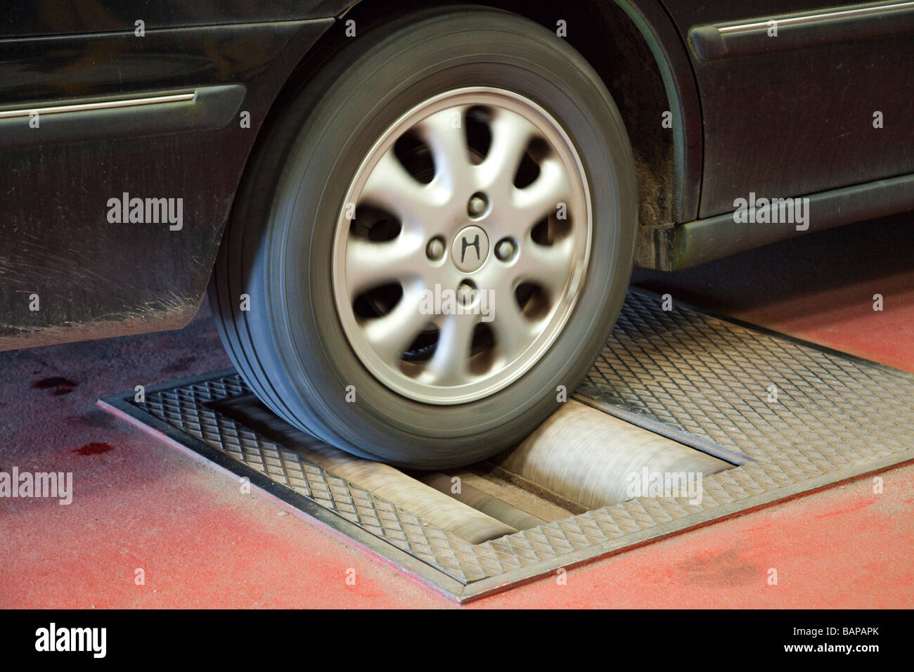 car on a rolling road / dynamometer to check brake efficiency during MOT  test in the UK Stock Photo - Alamy