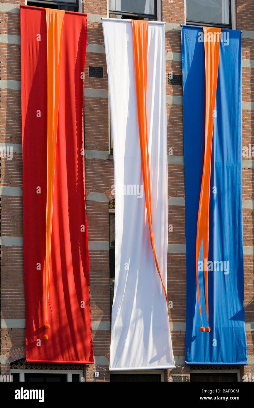 Dutch national flag, banners in the colors of the Dutch flag. On an Amsterdam canal on Queensday. Stock Photo