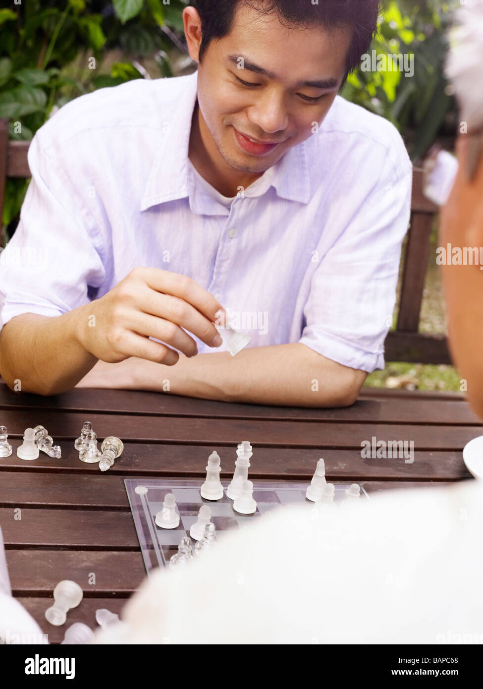 father and son playing chess game at garden Stock Photo