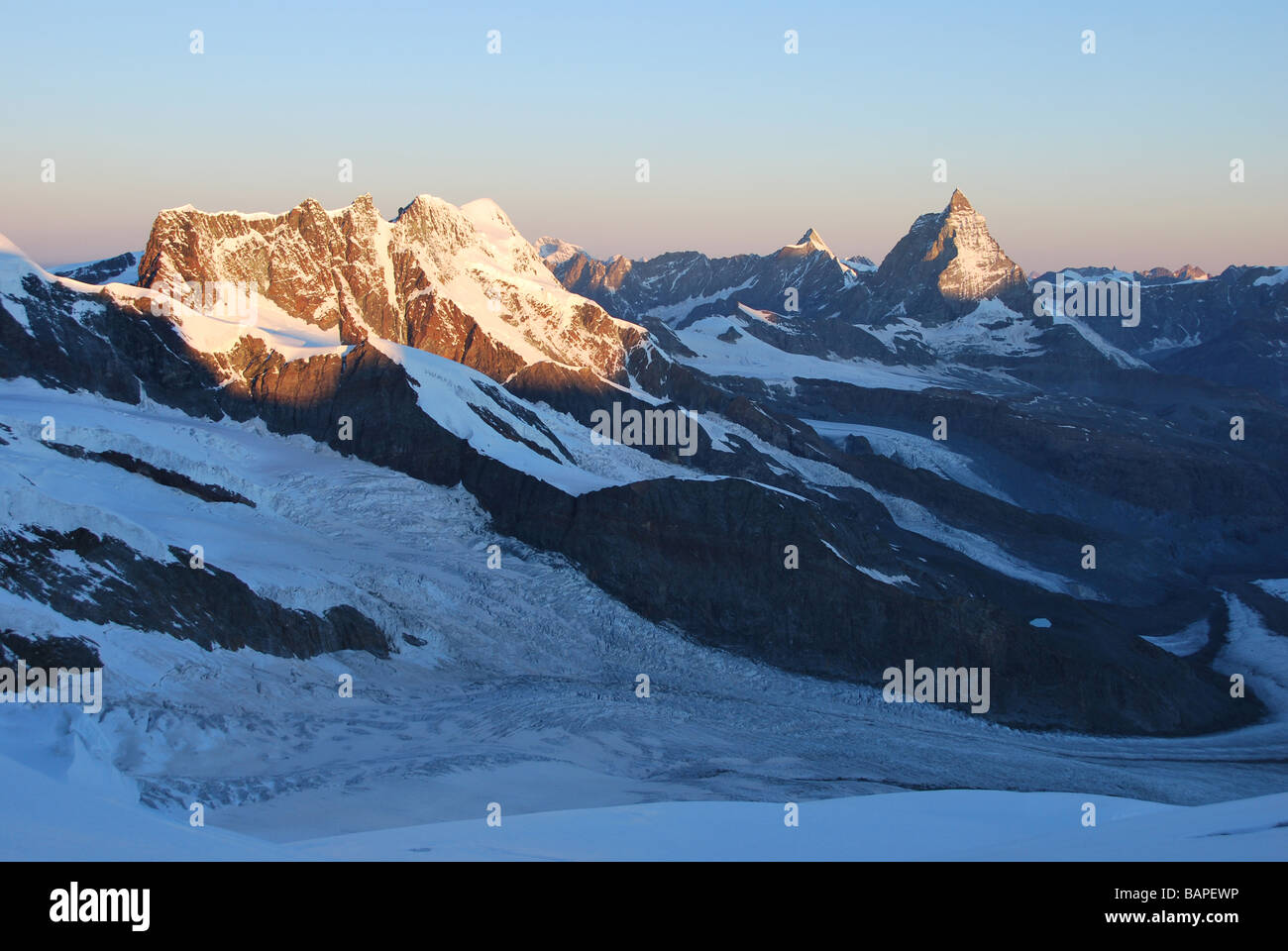 Alpine sunrise illuminates Matterhorn and Breithorn, swiss Alps Stock Photo