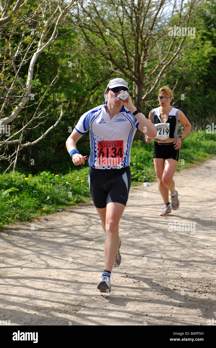 Man drinking water in marathon race, UK Stock Photo Alamy