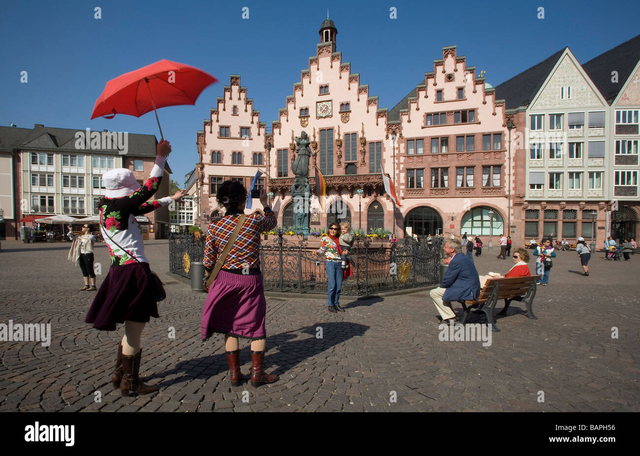 Roemerberg in the old town with historical buildings and a statue of Justitia (Justice): Japanese tourists taking photos Stock Photo
