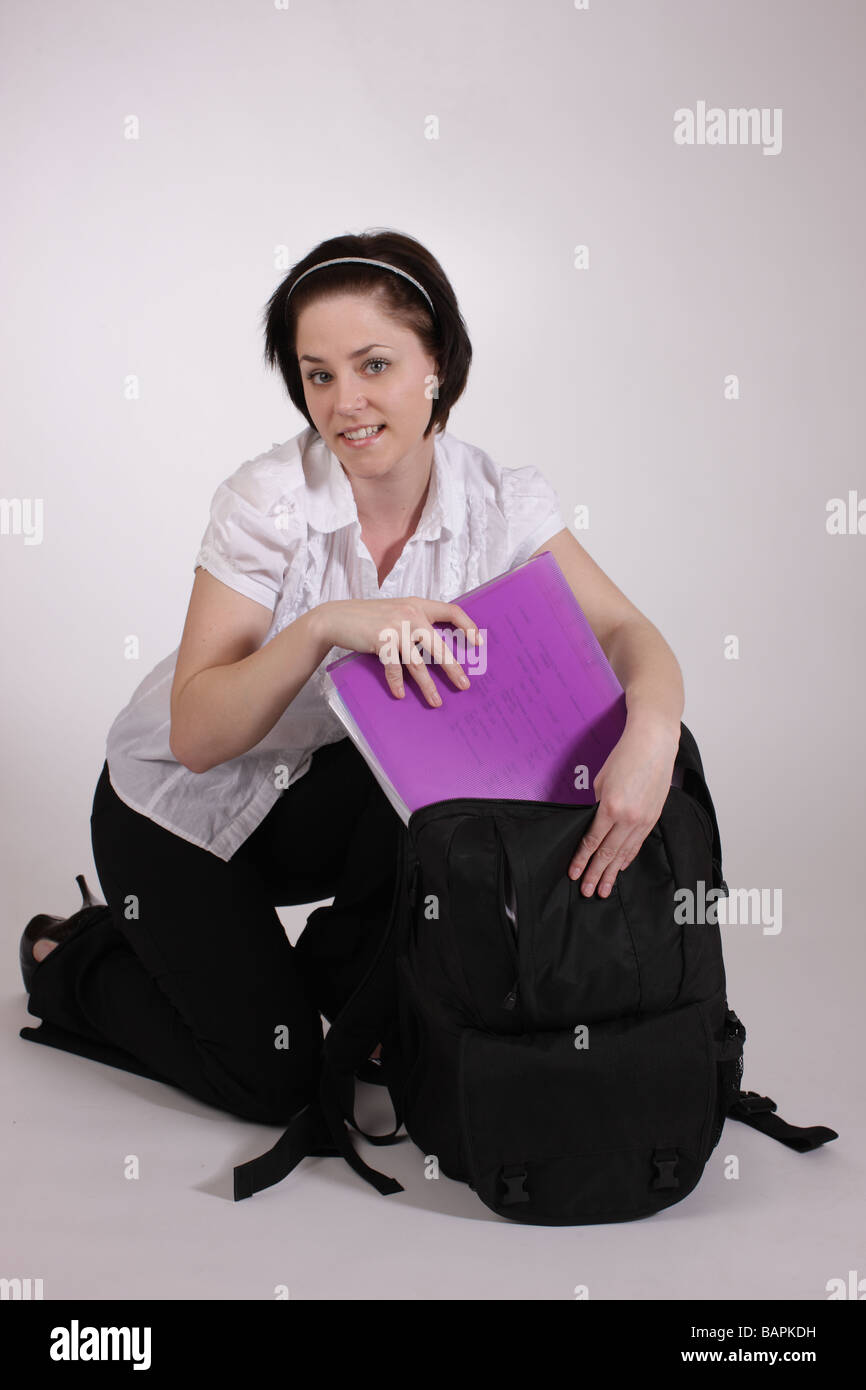 School girl putting folder with homework in bag or satchel Stock Photo -  Alamy