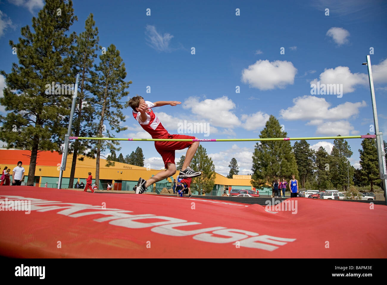 A middle school boys high jump during a school track and field meet on the field of a local junior high school Stock Photo
