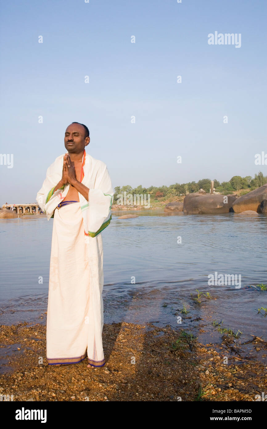 Man praying at a riverside, Hampi, Karnataka, India Stock Photo - Alamy