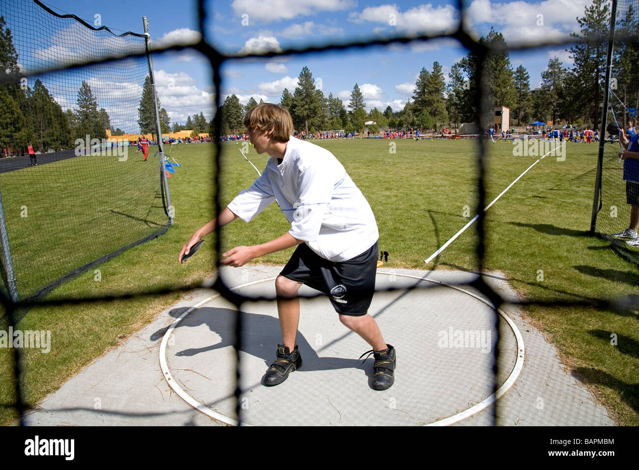 A middle school boys discus throw during a school track and field meet