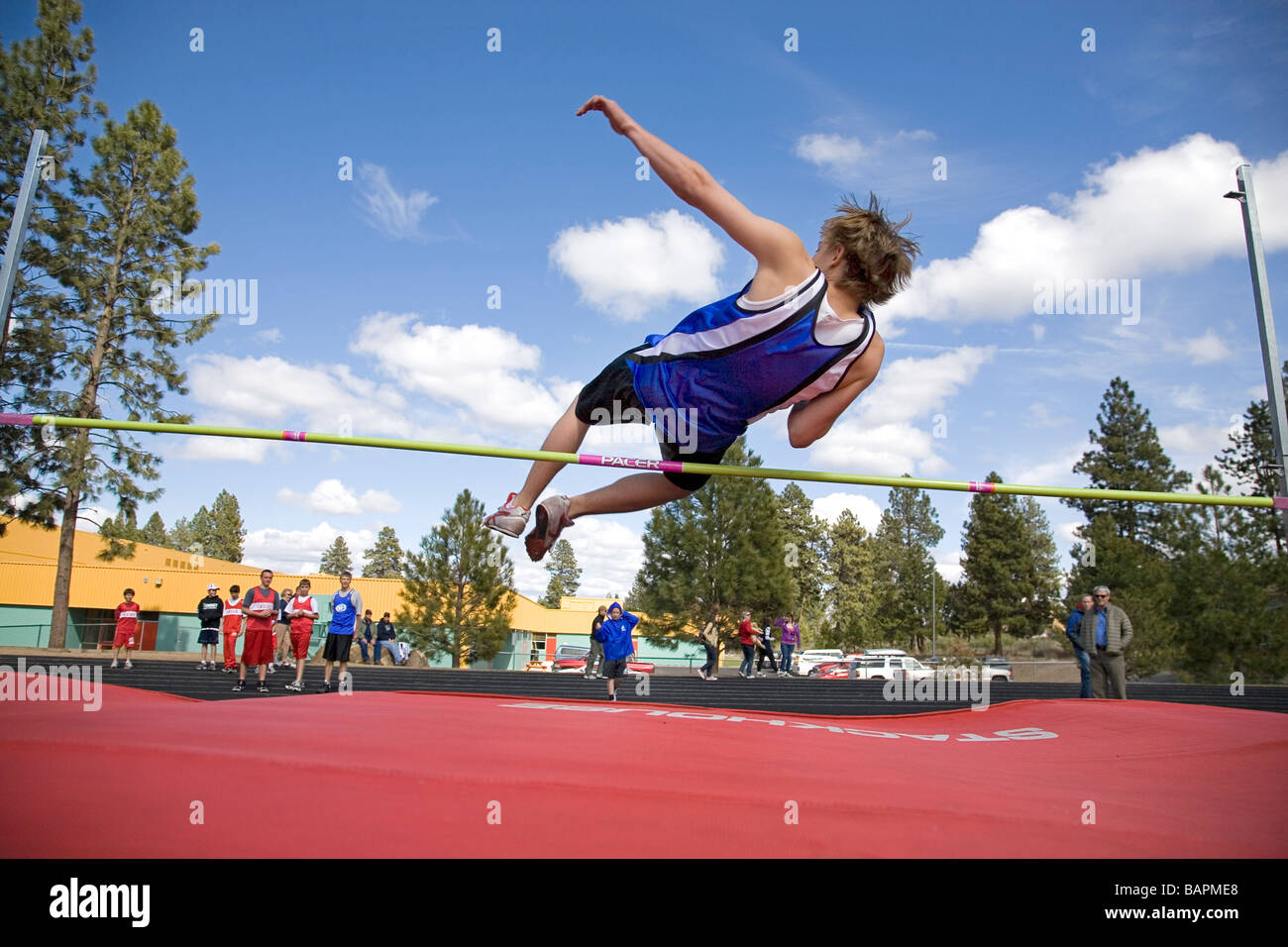 A middle school boys high jump during a school track and field meet on the field of a local junior high school Stock Photo
