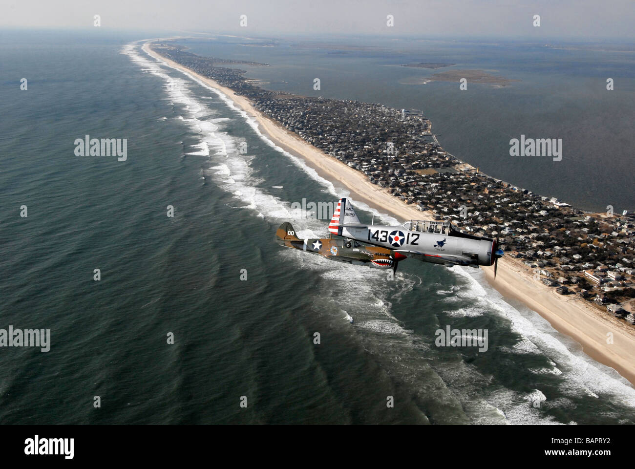 A 1935 silver T6 Texan and a 1935 Curtiss Wright P40 flying over Fire Island New York Stock Photo