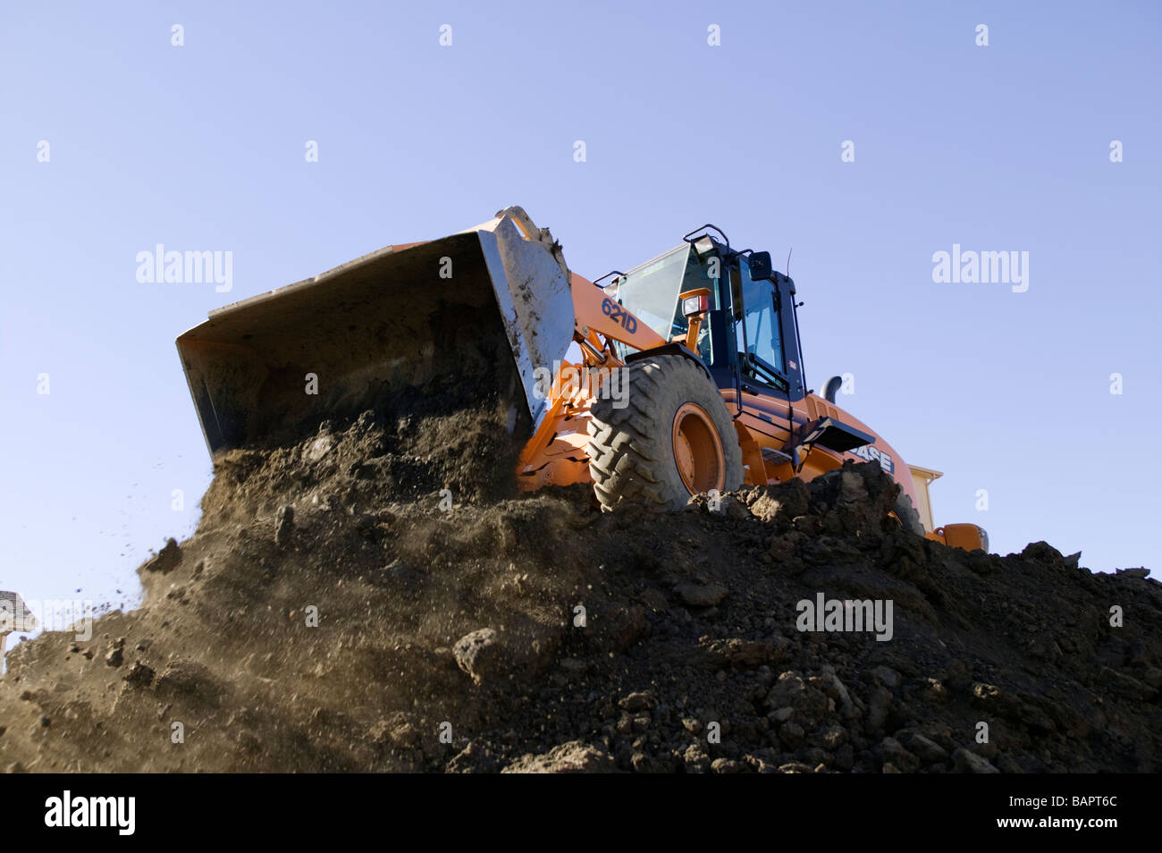 Front end loader excavating basements for new residential houses Stock Photo