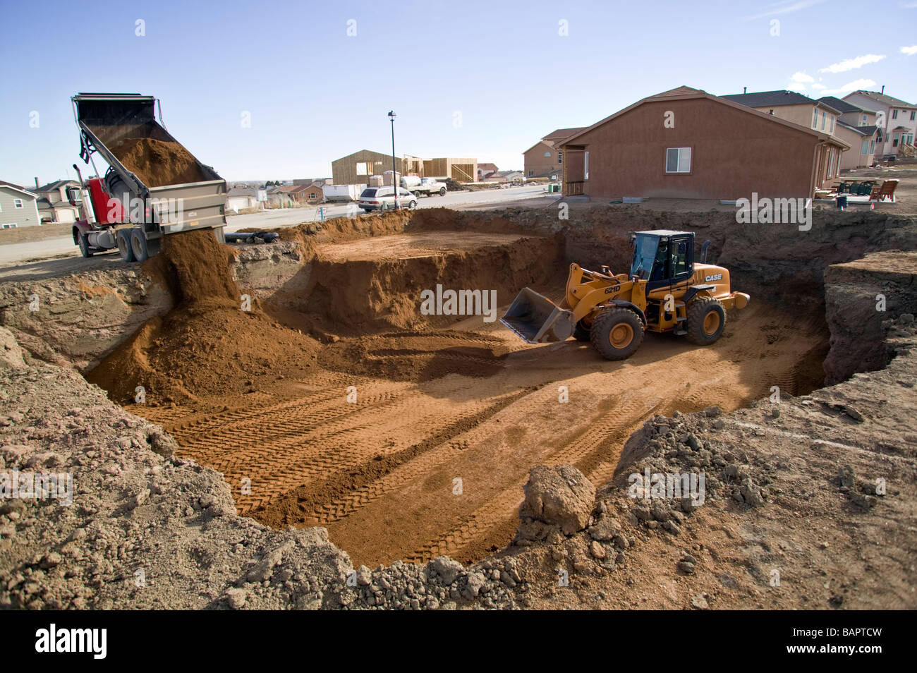 Front end loader excavating basements for new residential houses Stock ...