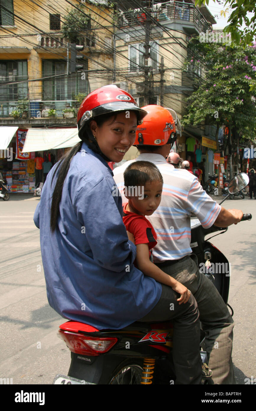 A family captured on a motorbike in the old town of Hanoi, Vietnam Stock Photo