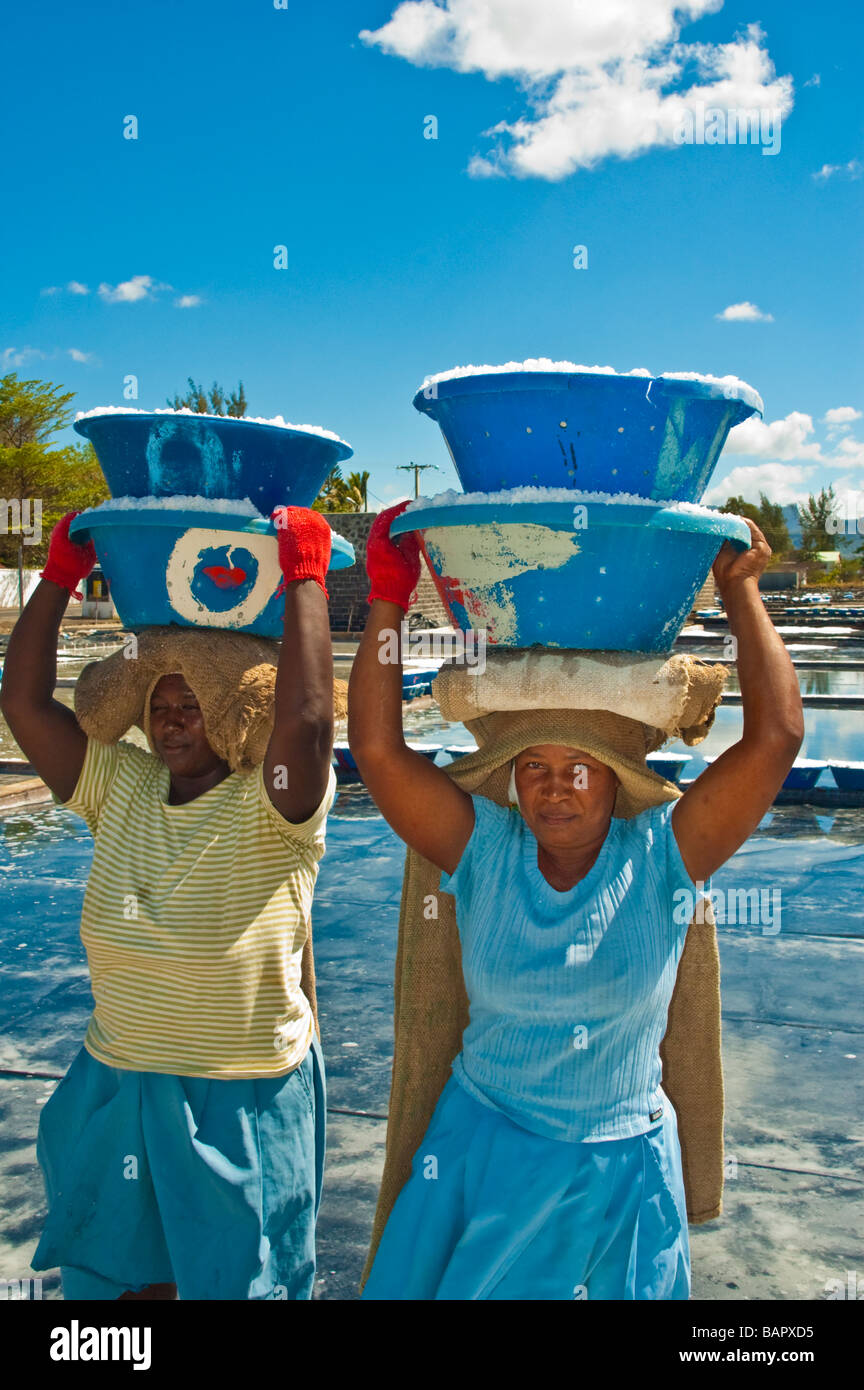 Salt production, woman carrying salt in front of salt pans near Tamarin Mauritius Stock Photo