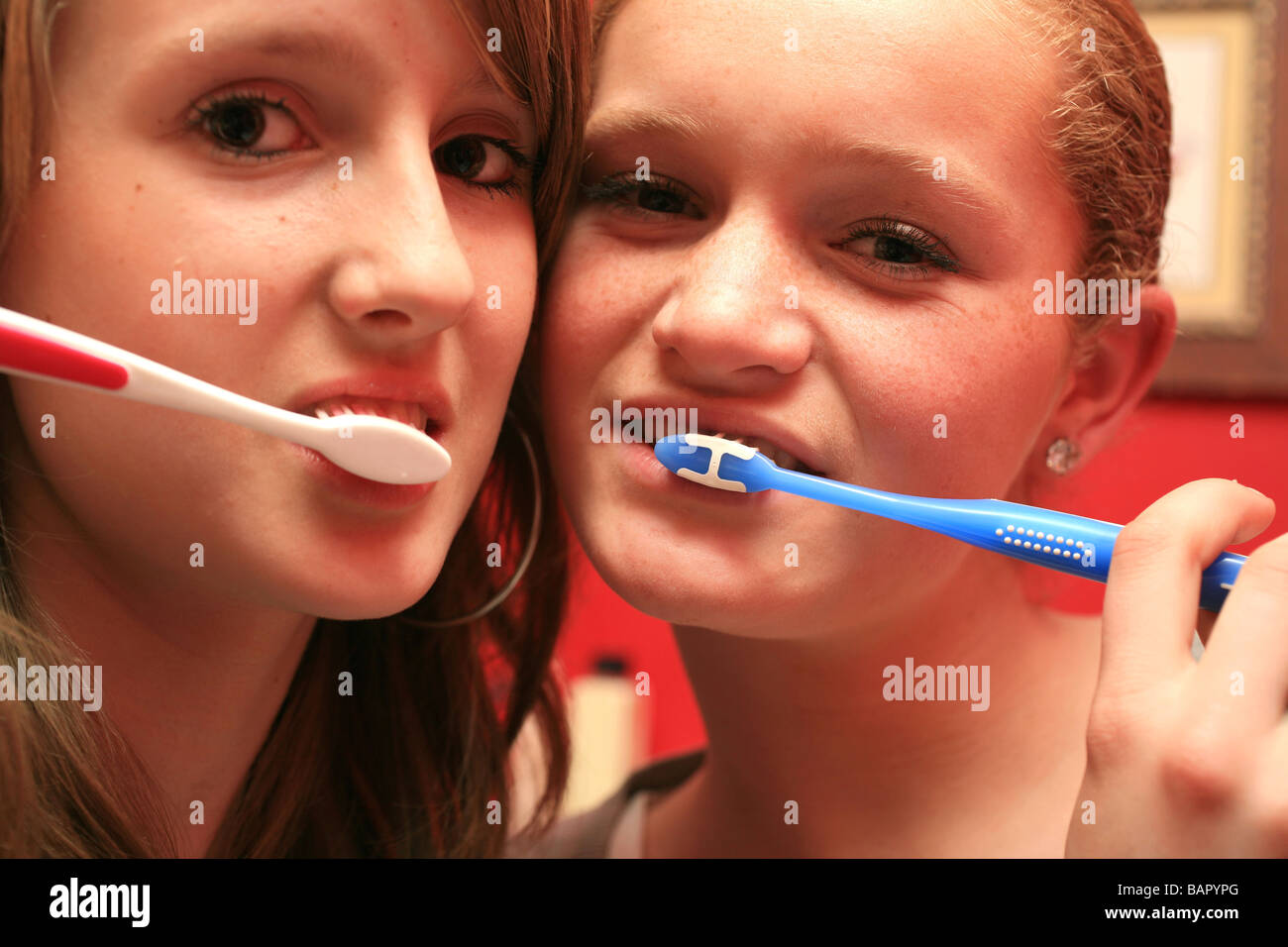 Teenage girls brushing there teeth Stock Photo