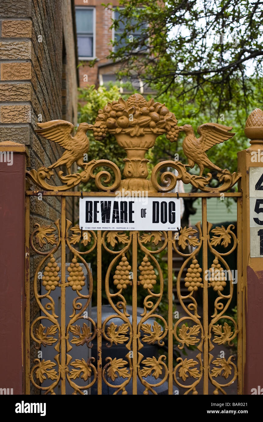 A beware of dog sign attached to a wrought iron gate Stock Photo