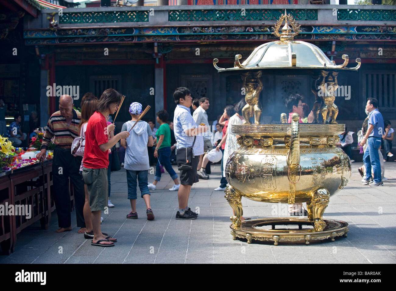 Buddhist and Taoist worshippers burning incense sticks as a ritual offering at Lungshan Temple