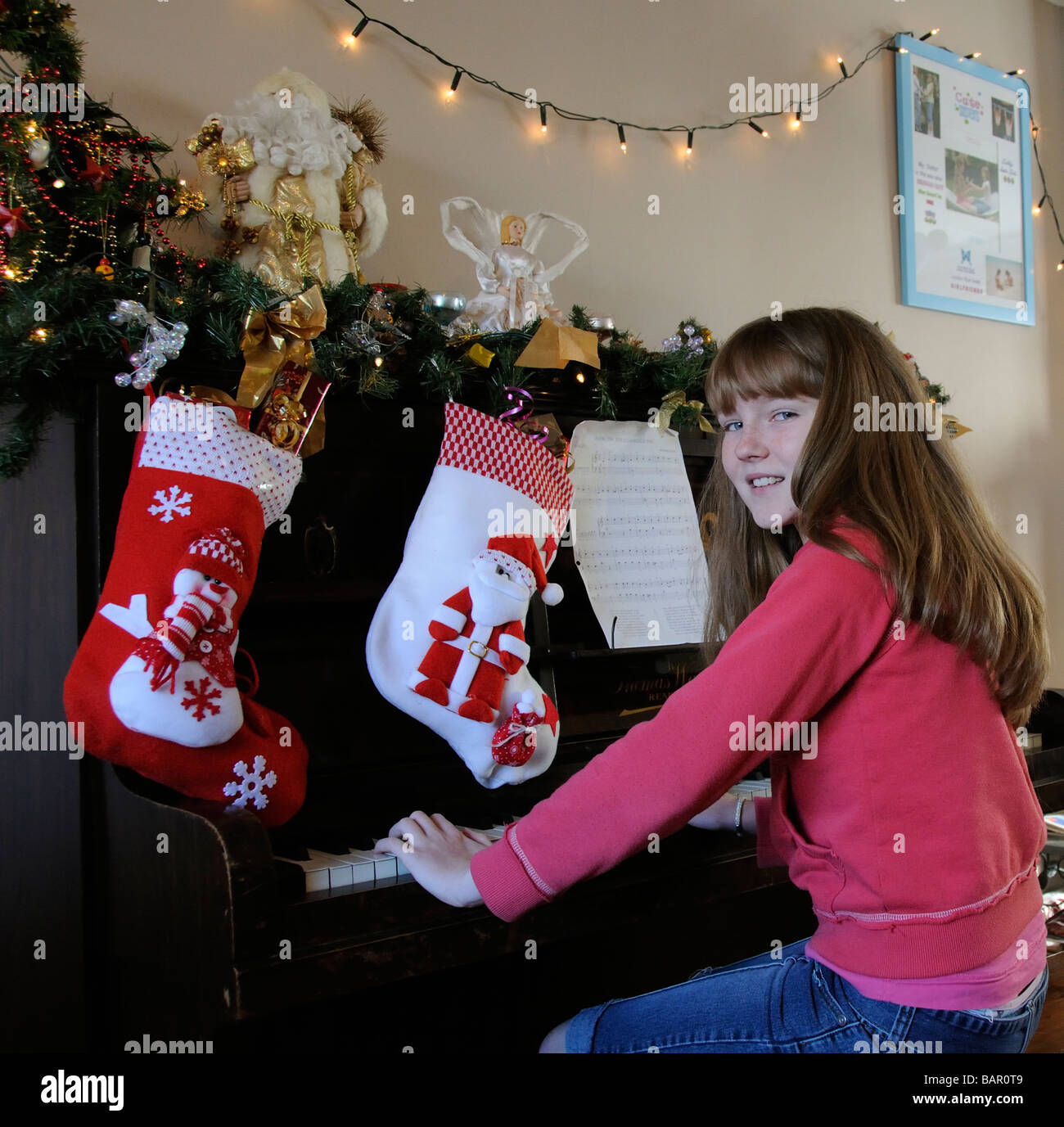 Little girl playing the piano decorated for the festive season at Christmas Stock Photo