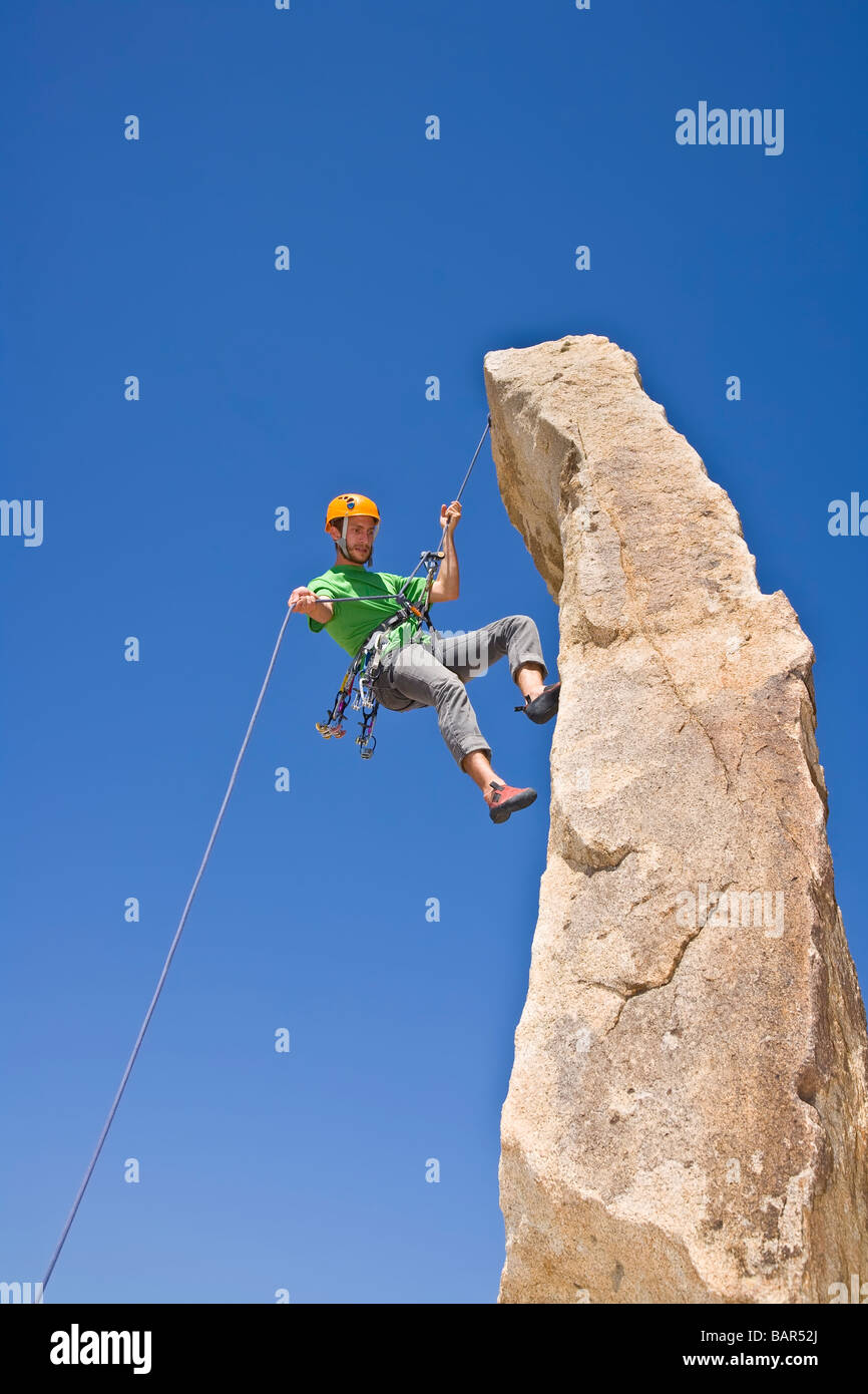 A rock climber rappelling from a rock spire Stock Photo Alamy