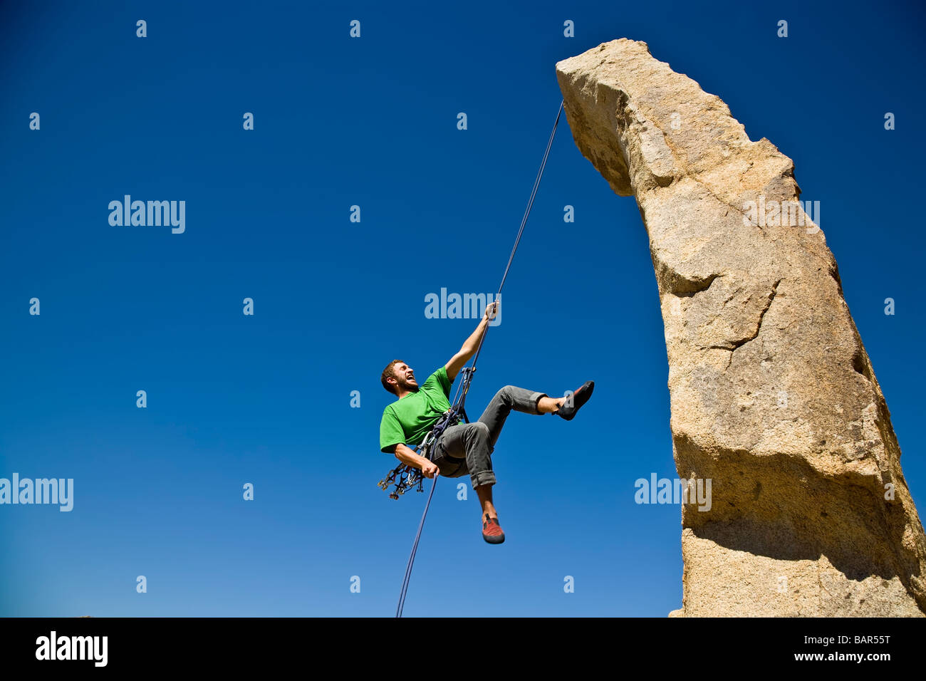 A rock climber rappelling from a rock spire Stock Photo Alamy
