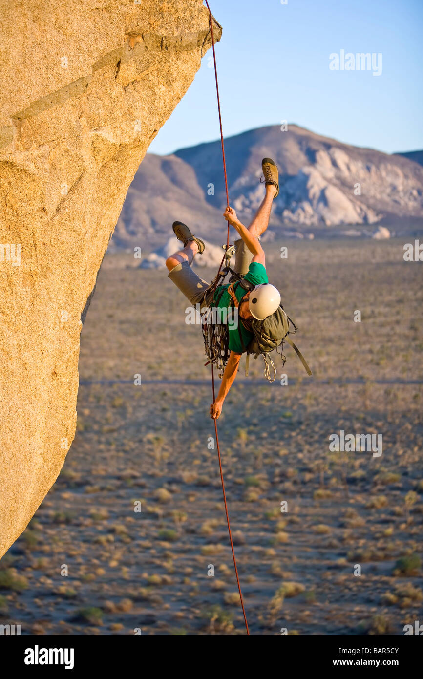 A rock climber rappelling past an overhang Stock Photo Alamy