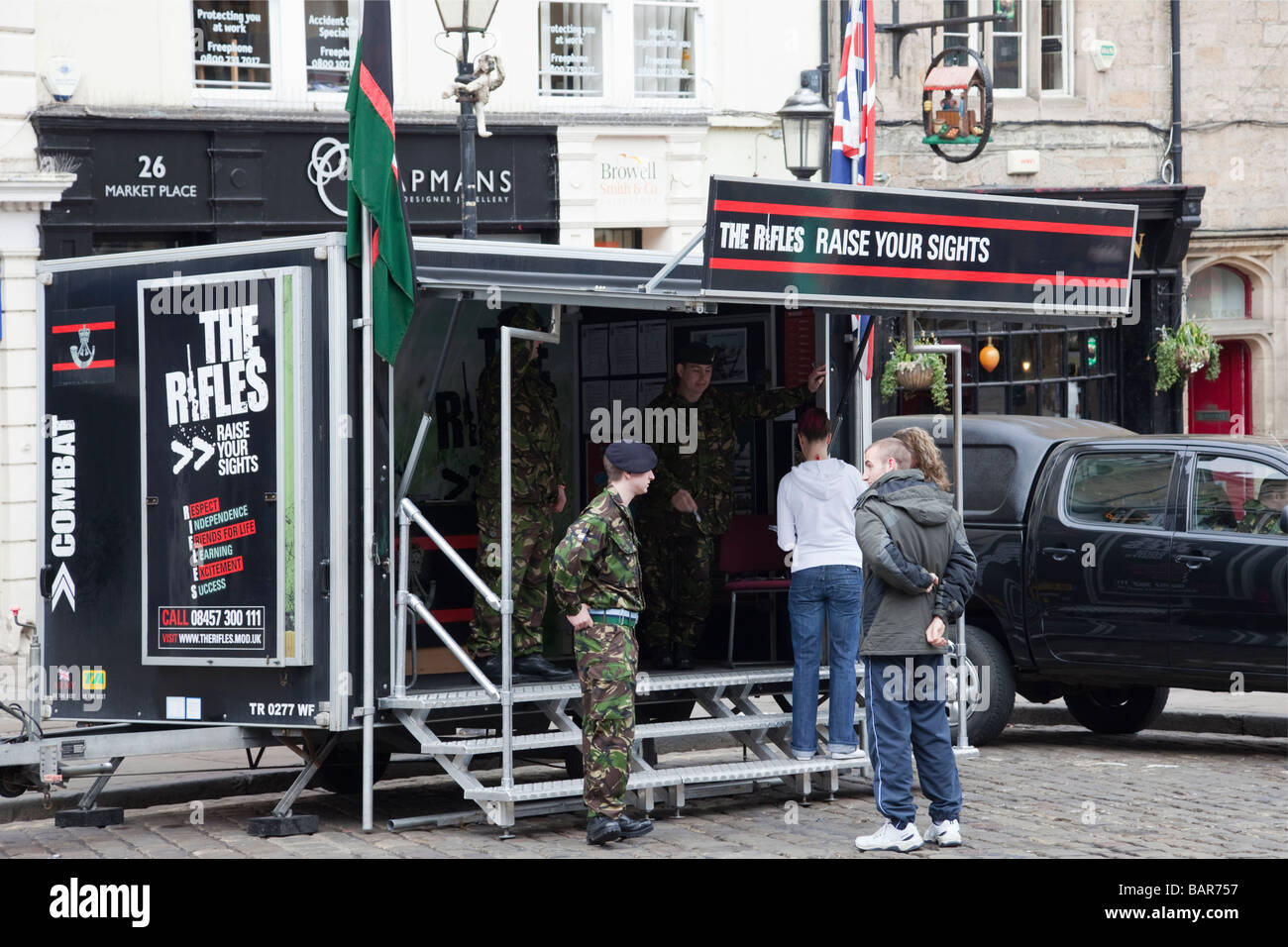 Army recruitment stand for The Rifles regiment with young people enquiring about joining the British armed forces. England UK Britain Stock Photo