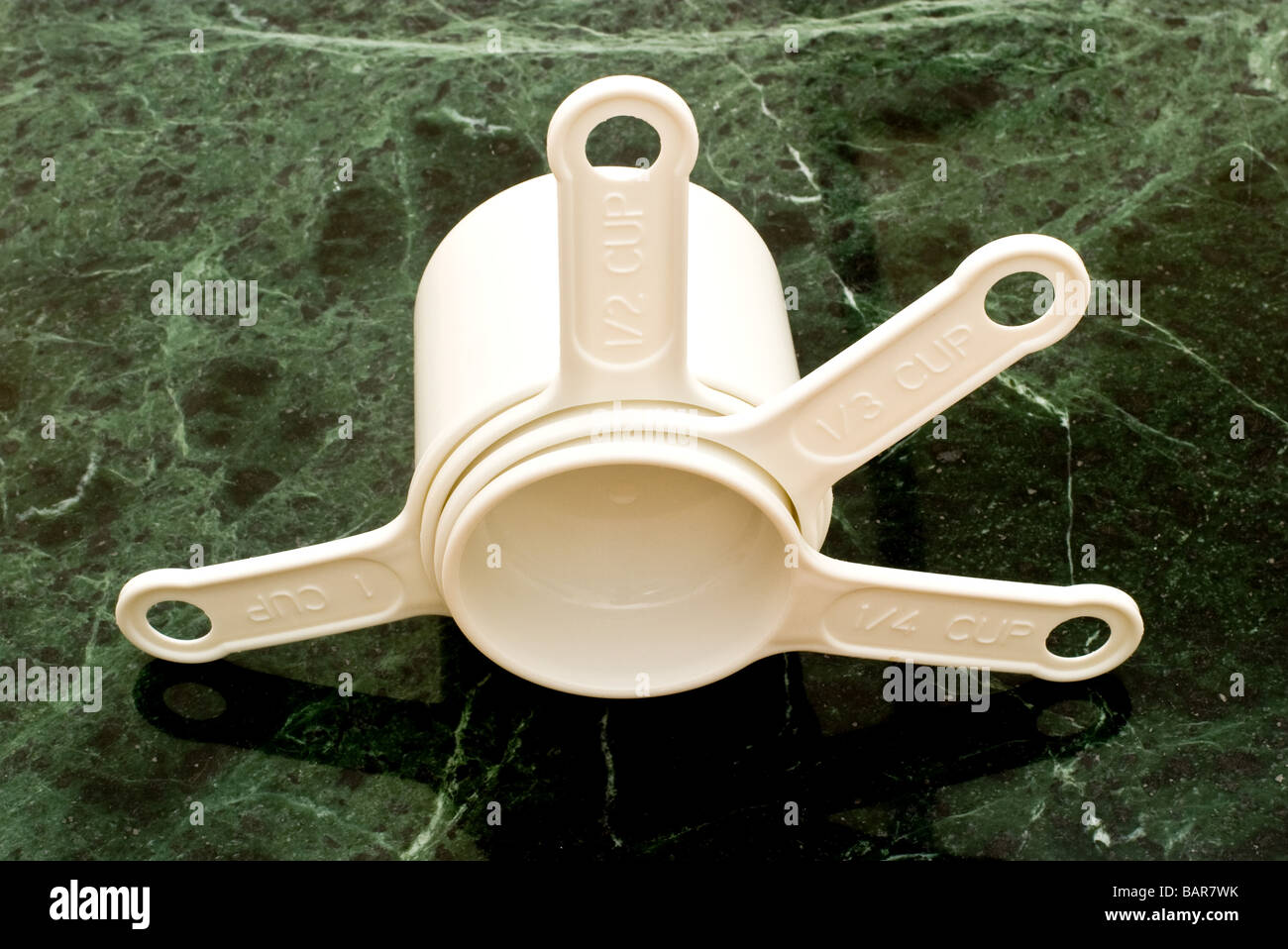 4 white plastic measuring cups of different sizes arranged from