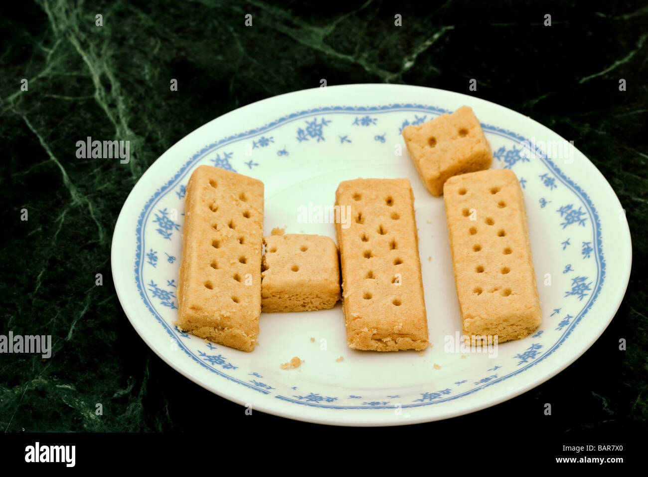 Shortbread cookie fingers on a white decorated plate spelling the work HI. Stock Photo