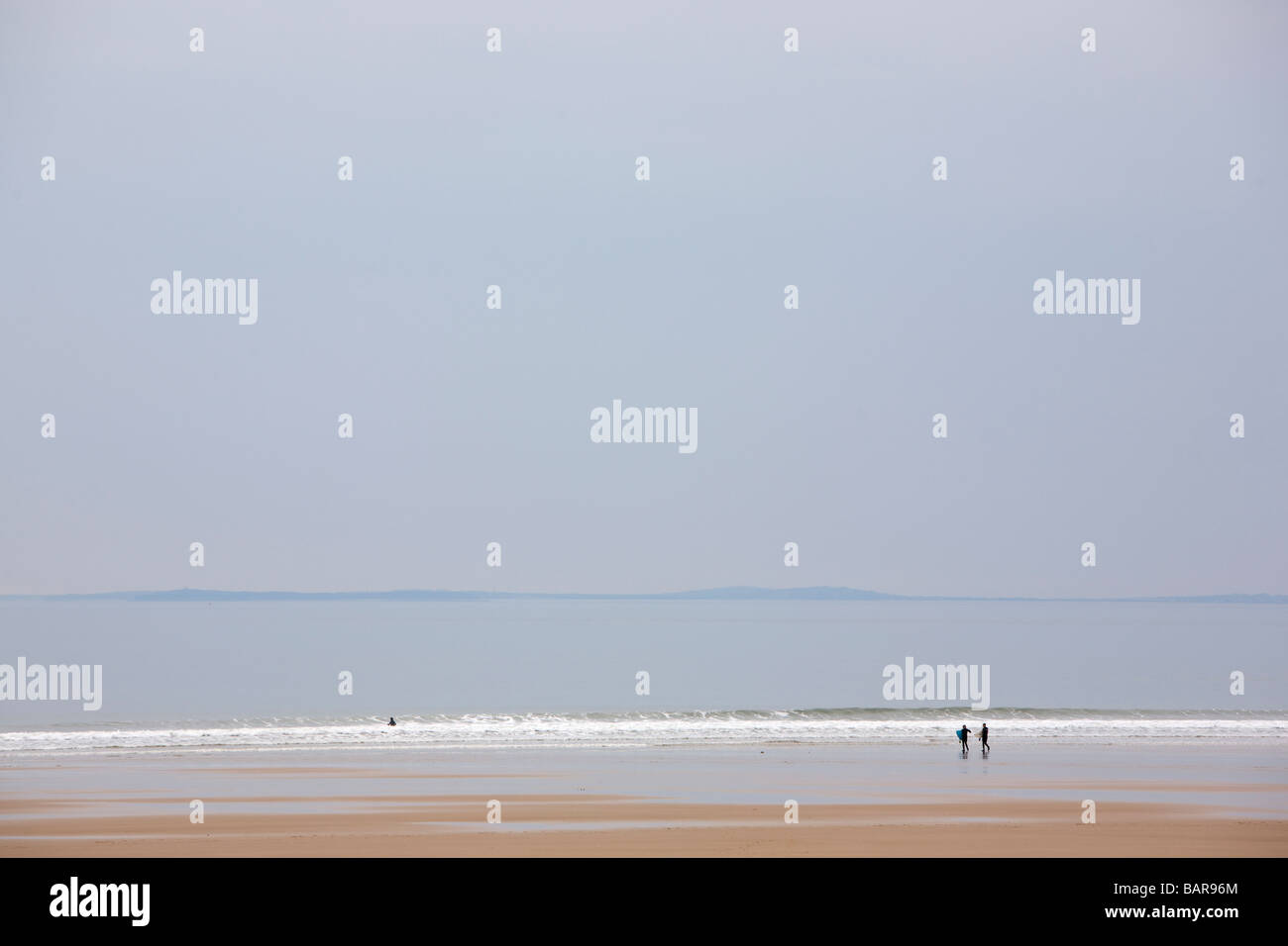 People on a beach under grey skies. Stock Photo