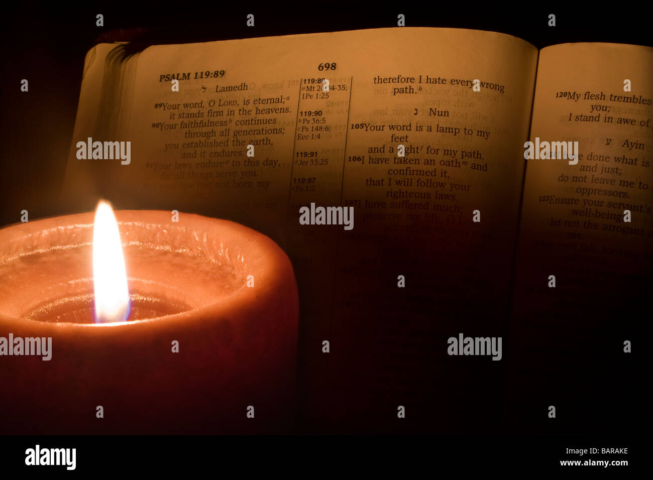 From the Bible, Psalms 119:105 being illuminated by a burning candle Stock Photo