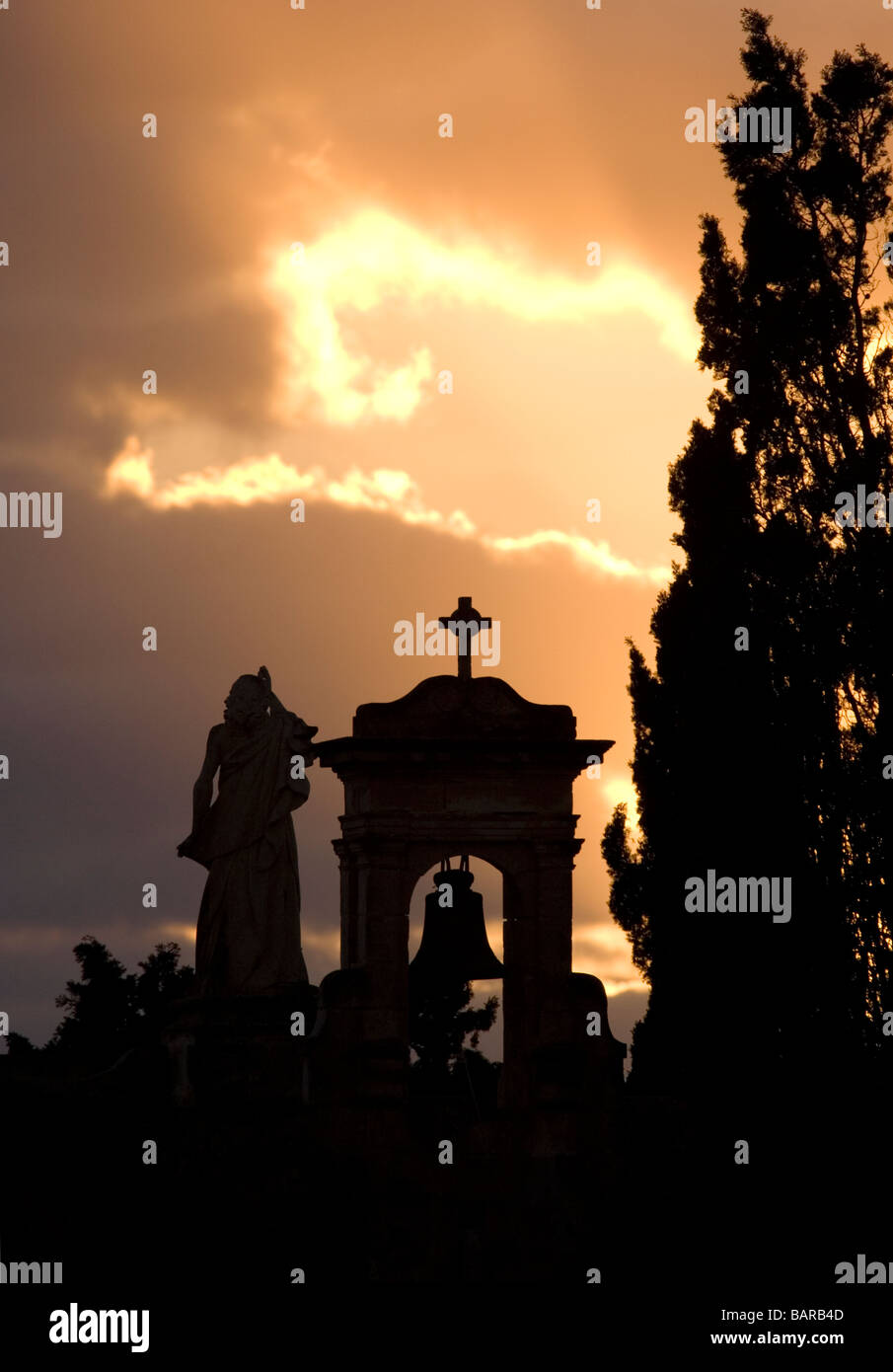 Belfry on chapel in silhouette at sunset. Close up view. Representation of Roman Catholic Christian faith, Catholicism, Christianity, afterlife. Stock Photo