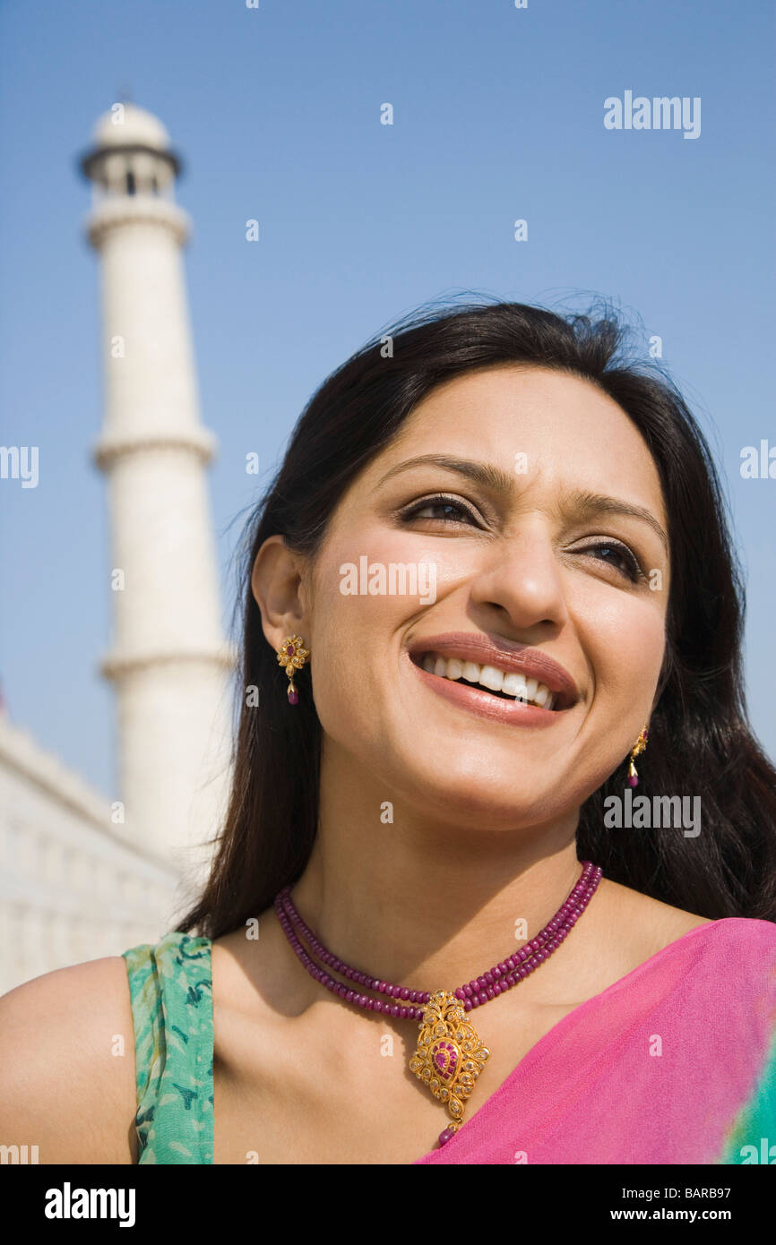 Woman smiling with a mausoleum in the background, Taj Mahal, Agra ...