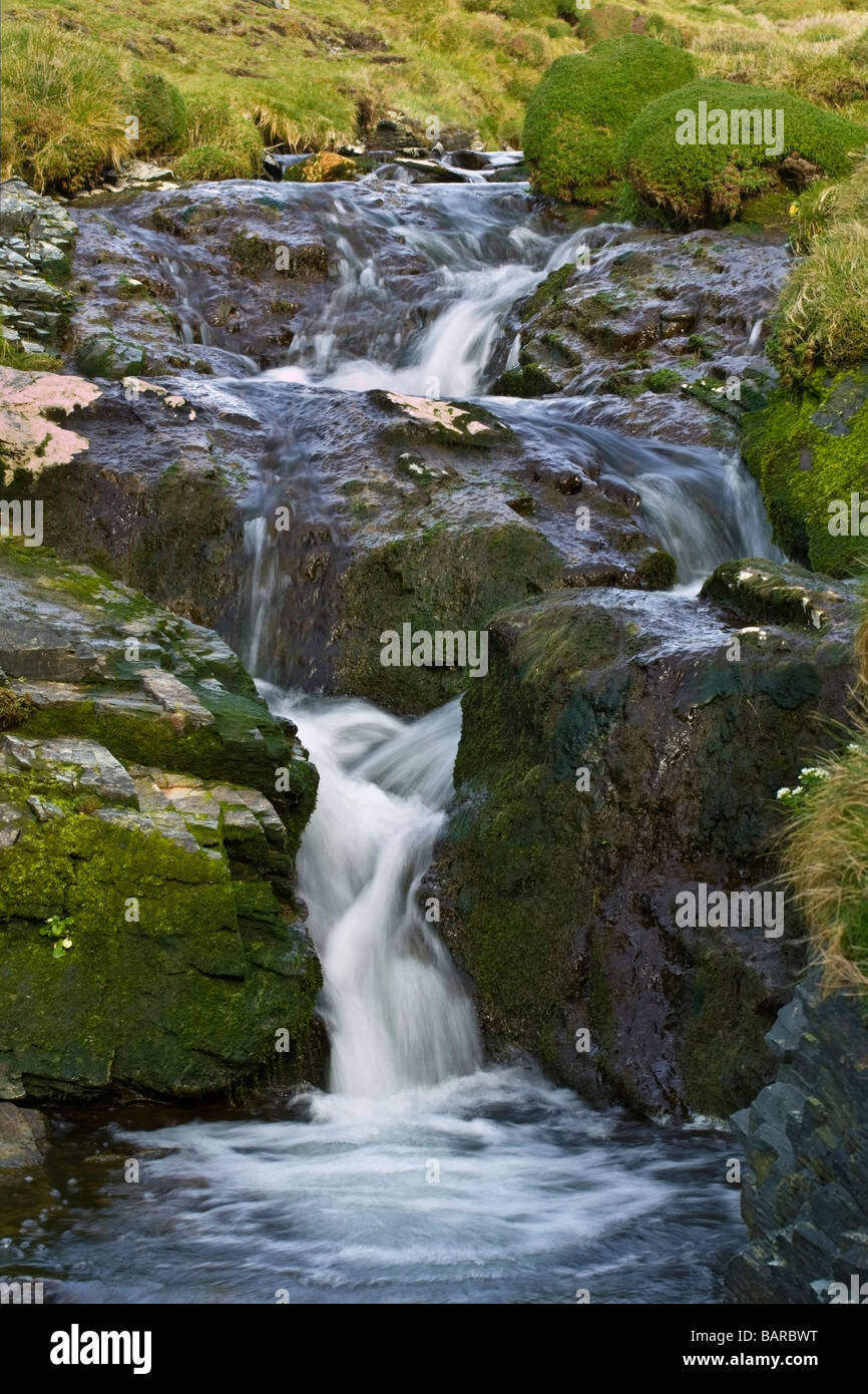 Study of a stream and its fall between two large rocks. Shutter speed relatively slow giving a 'silky' effect to the water Stock Photo