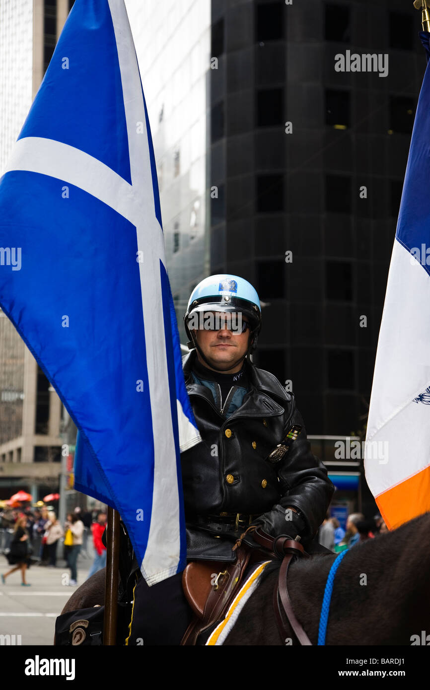 New York Police Officer on horseback holding the Scottish flag during the Tartan Day Parade along 6th Avenue New York Stock Photo