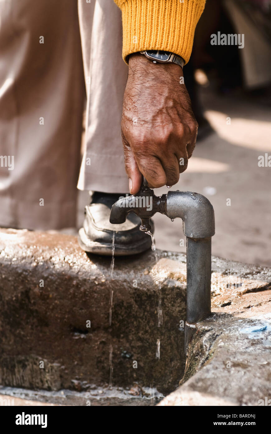 Man closing the faucet after washing hands, Delhi, India Stock Photo