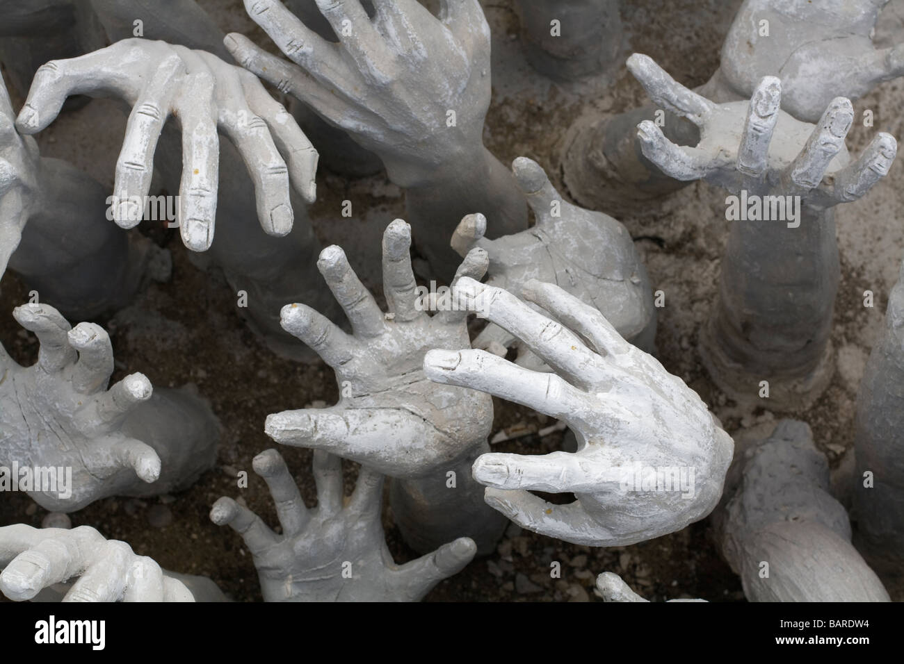 A sculpture of hands reaching up at you at Wat Rong Khun temple, Thailand Stock Photo