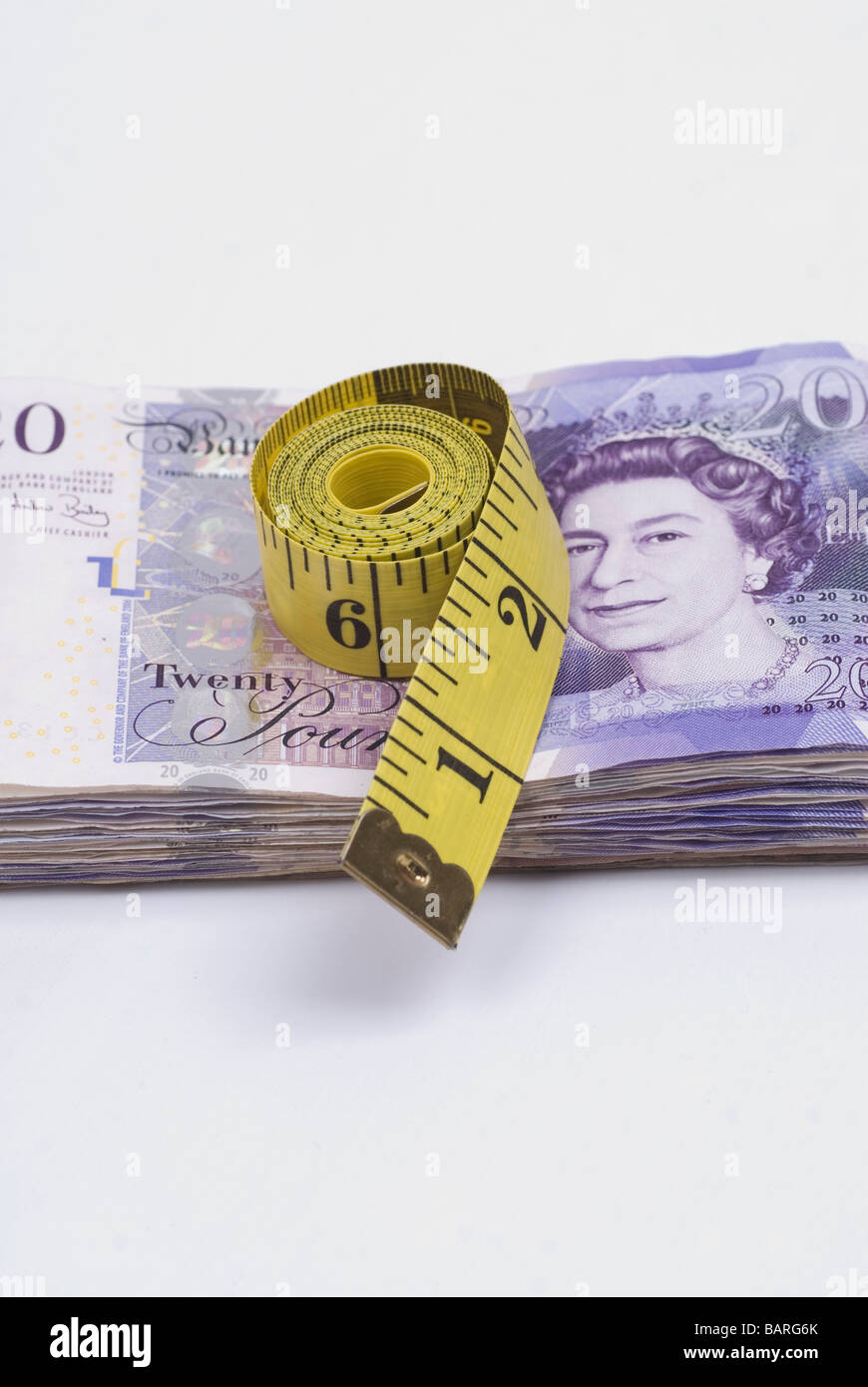 Tape measure over a pile of British money Stock Photo - Alamy