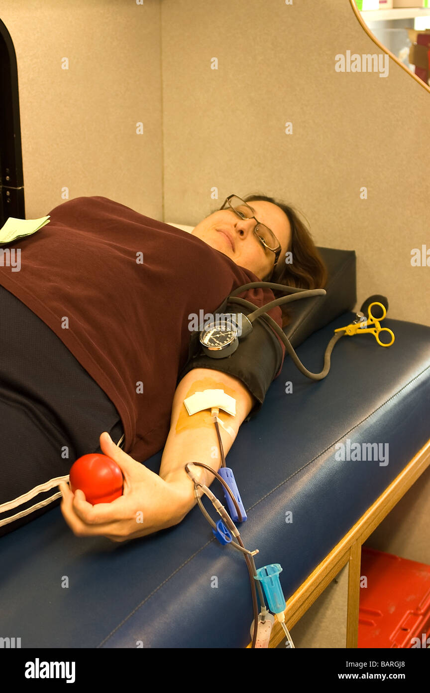 A woman giving blood in a Red Cross blood mobile; University Synagogue