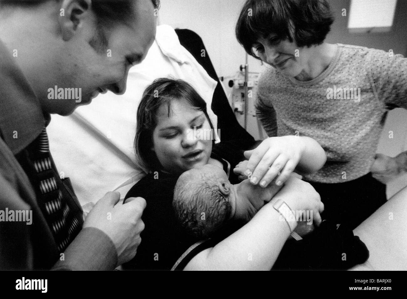 Mother Jenny holds her baby Erin moments after giving birth attended by her husband and mother at the Homerton Hospital. Stock Photo
