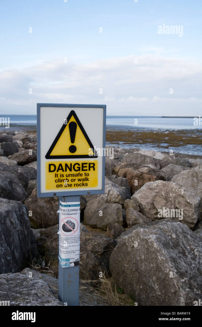 danger sign warning against climbing on rock armour sea defenses Stock Photo