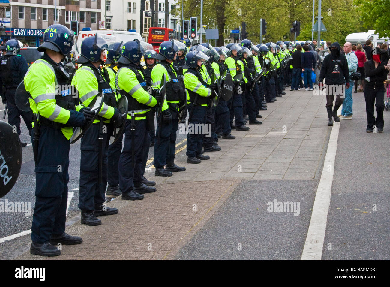 Riot police line the road observing protests during may day protests in Brighton, Sussex, UK JPH0192 Stock Photo