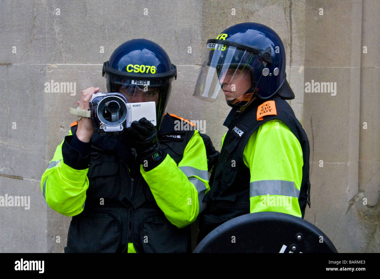 Riot police filming the crowd and events during may day protests in Brighton, Sussex, UK JPH0193 Stock Photo